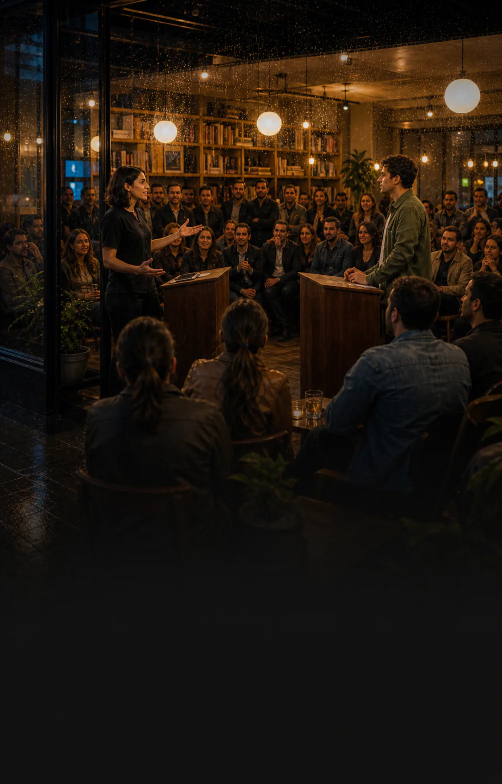 Two debaters address a packed city debate night in a warm coworking venue